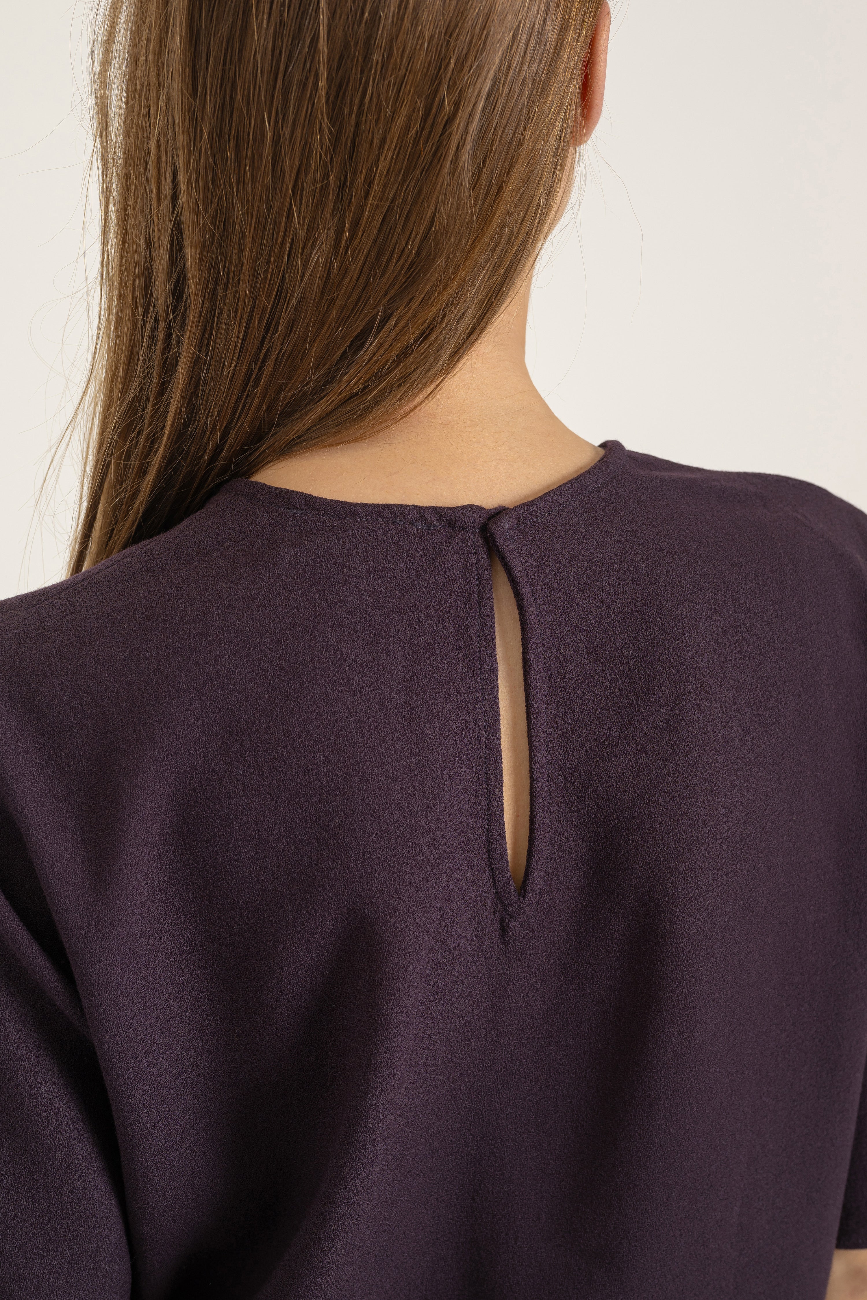 Top Daphne en crêpe de laine prune porté avec Pantalon Billie en velours de coton camel, détail | Mardi Editions