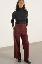 Pantalon Louise en laine bordeaux porté avec Pull Raoul en laine gris anthracite | Mardi Editions